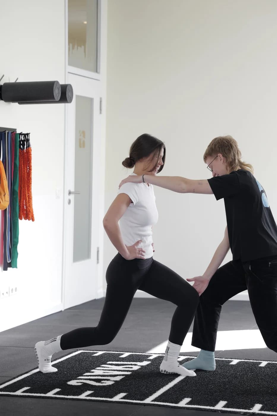 Trainingsraum-Detail mit Therapeutin und Patientin — Praxis Vier Punkt Null Hamburg-Lokstedt.